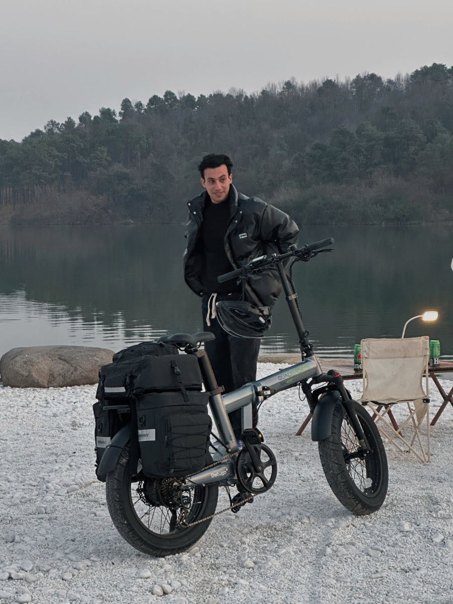 Person with a qualisports beluga plus folded electric bike by a lake