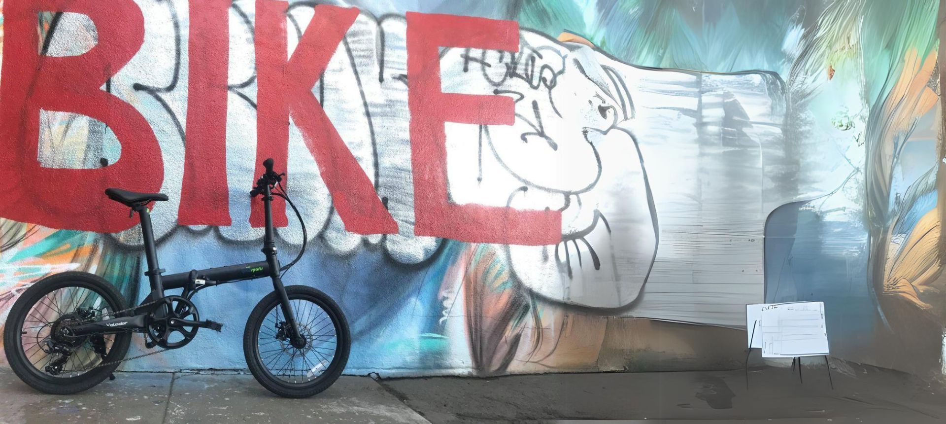 best folding ebike volador parked in front of wall with bike graffiti