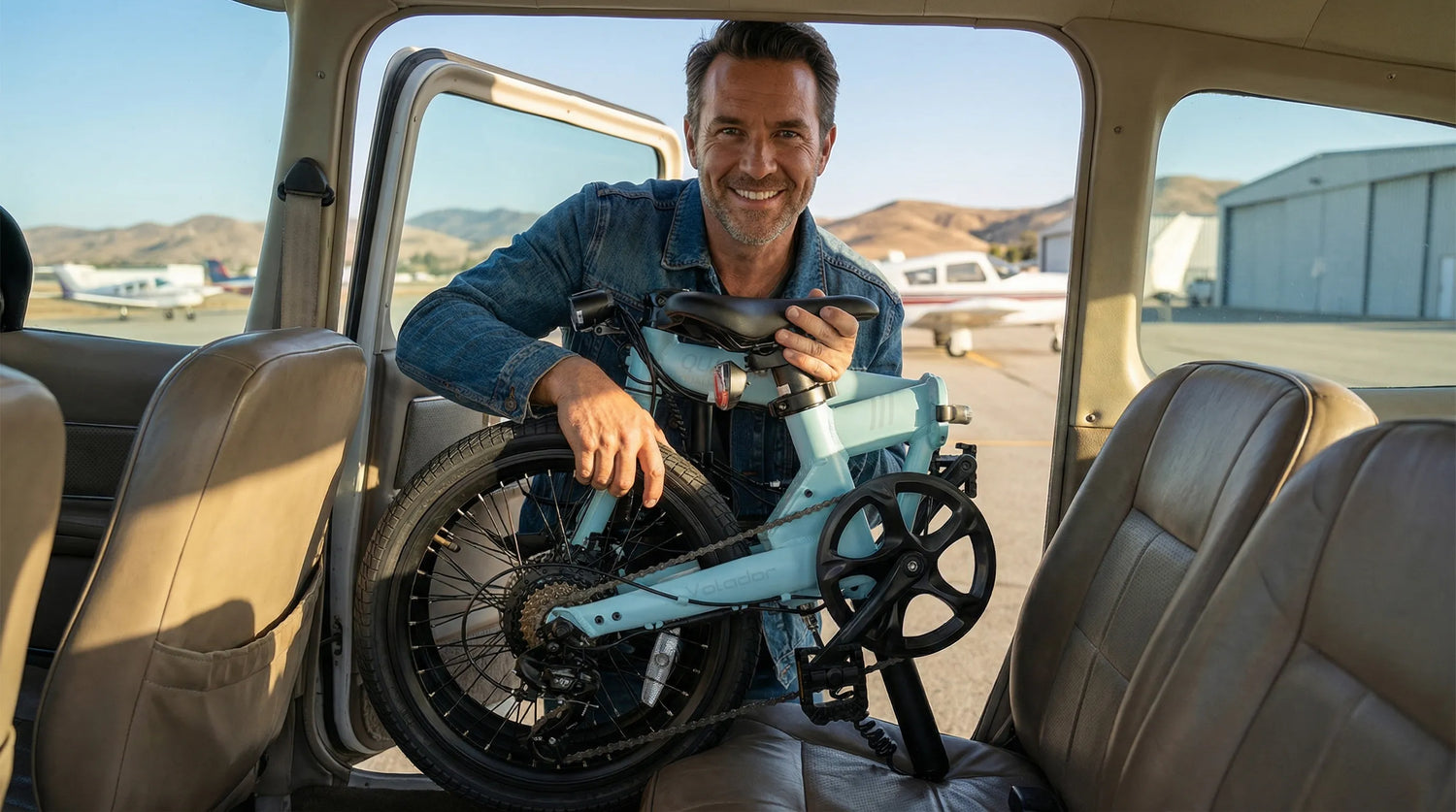 Man holding a conpact folded electric bike inside an small plane with a scenic background.
